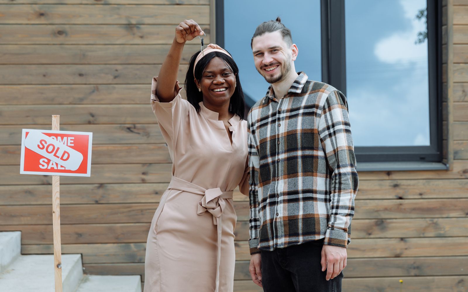 Couple celebrating buying their first house, keys in hand