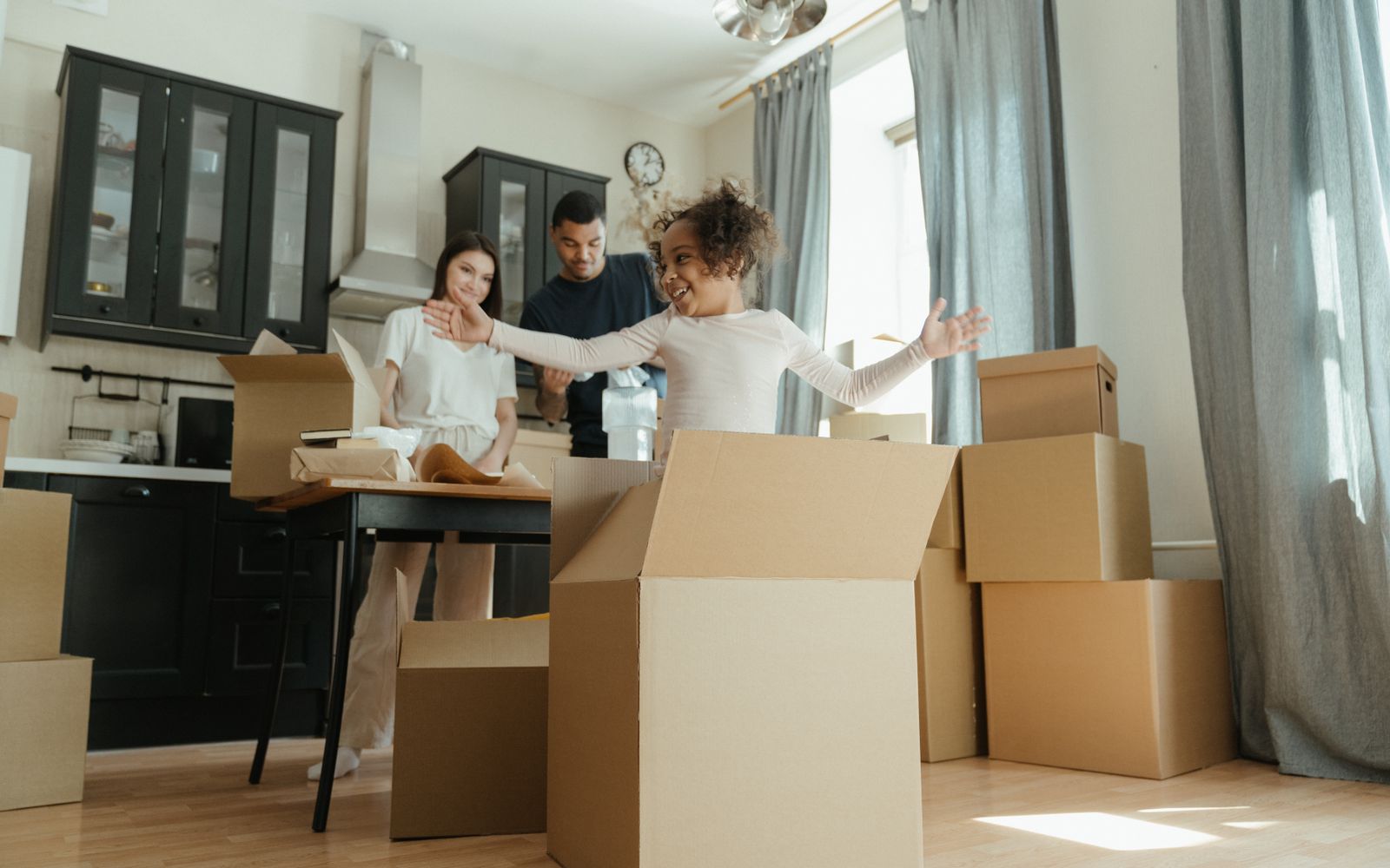 Family unpacking boxes in the kitchen of their next home