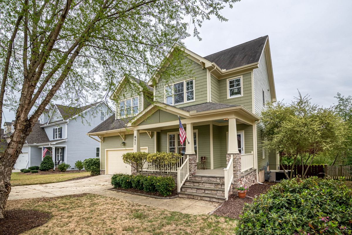 Two-story house with a front porch and American flag