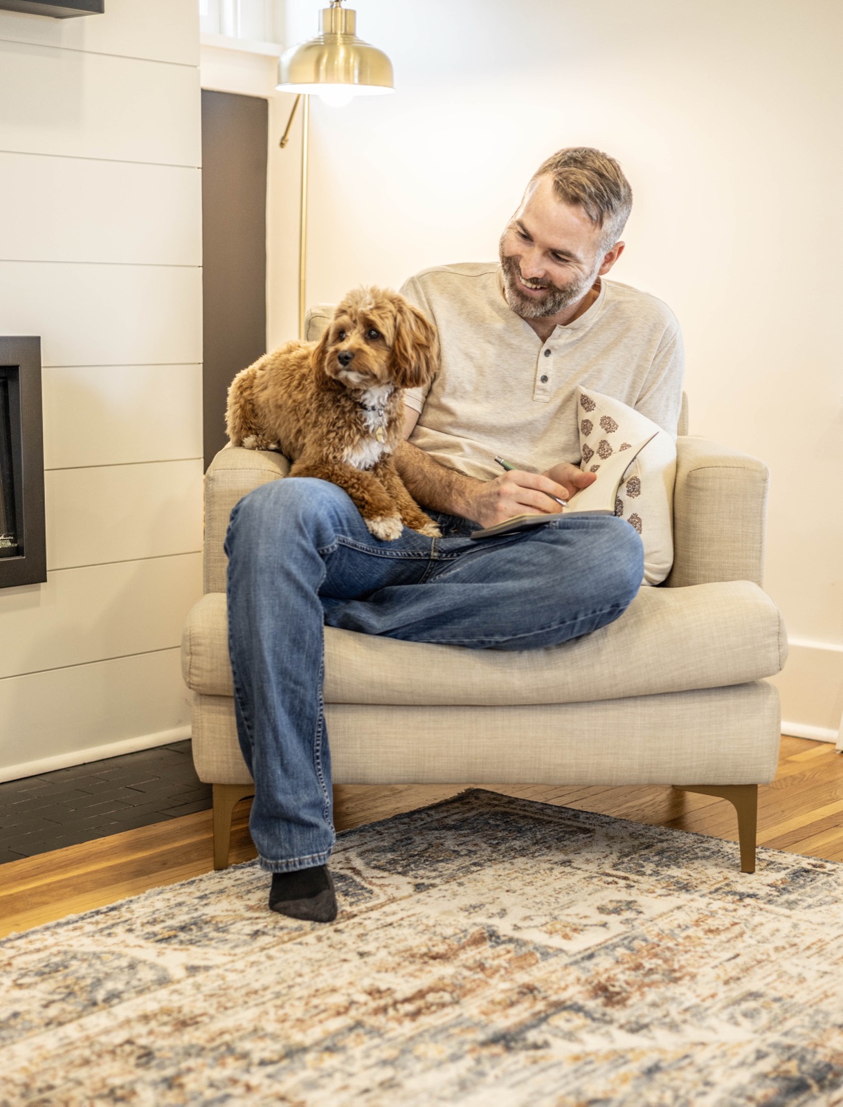 Wade Bartels at home in an armchair with his dog on the armrest