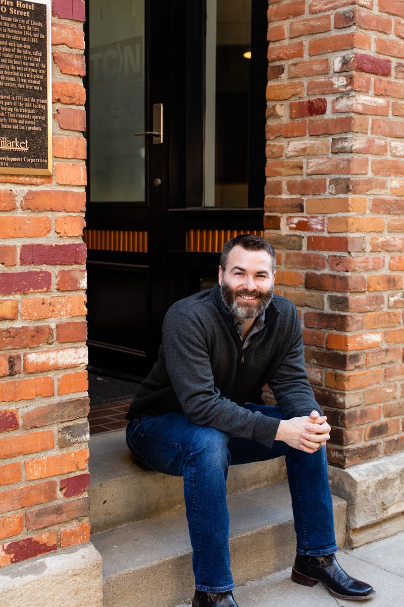 Wade Bartels sitting on brick steps in Lincoln's Haymarket