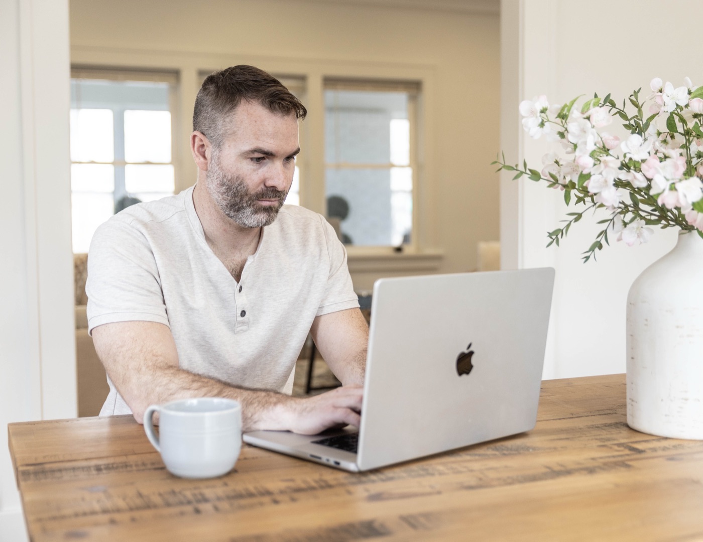 Wade Bartels working at the kitchen table with a cup of coffee