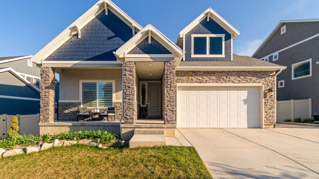 A charming modern suburban home with a stone facade and a neatly maintained lawn.