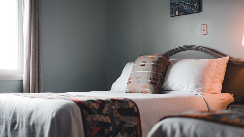 Inviting hotel room interior with a neatly arranged bed and soft lighting.